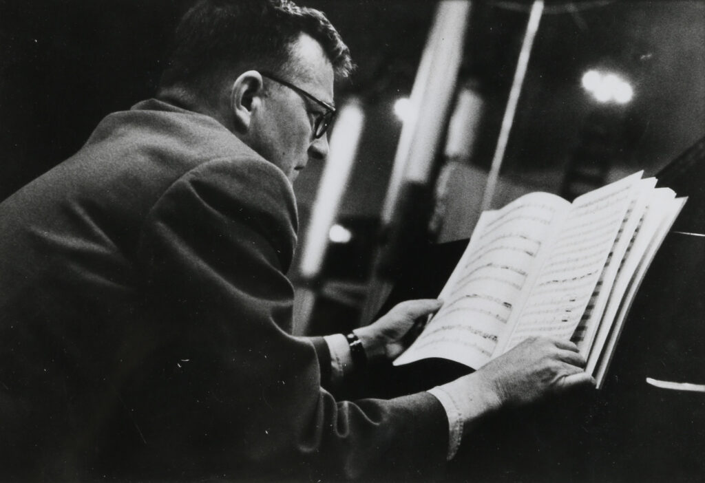 Louis INGIGLIARDI, dit INGI (1915-2008). "Dimitri CHOSTAKOVITCH (1906-1975), Compositeur". Prises de vues le 9 mai 1958 à la salle Wagram lors de l'enregistrement de son Concerto. Tirage argentique d'époque 19.7 x 24.6 cm. Oeuvre mise en vente par Vichy Enchères le 2 juin 2025 © C. Darbelet