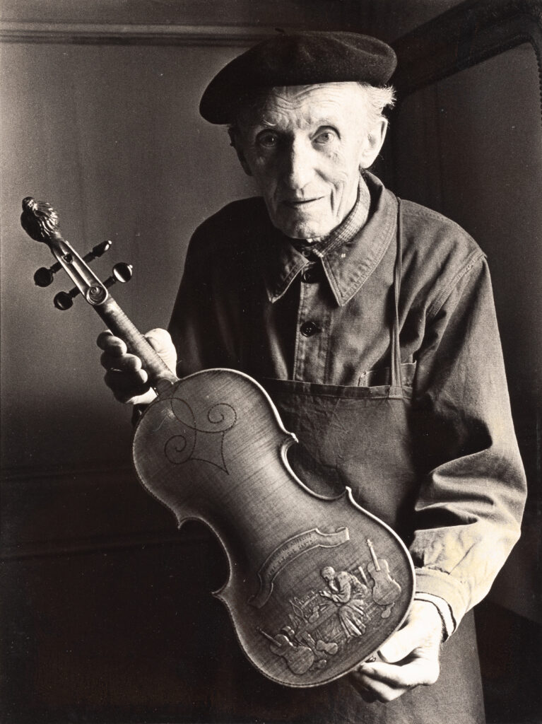 Portrait de Gustave VILLAUME présentant son violon dédié à sa femme Berthe MALLAGNACQ.
Fonds d'atelier Gustave VILLAUME.
Photographie mise en vente le 1er décembre 2025.
© Vichy Enchères/C. Darbelet
