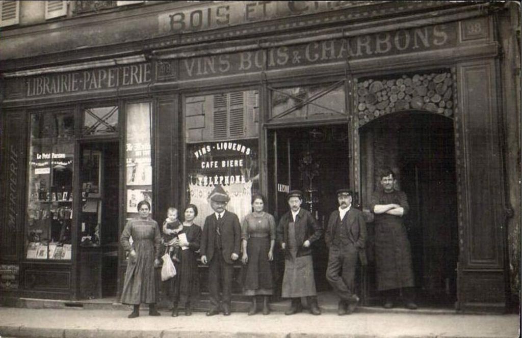 Photographie d’une famille de bougnat devant un café-charbon parisien, début XXe siècle tirée de https://blogs.univ-jfc.fr/vphn/2023/04/13/les-aveyronnais-de-paris-1830-1960/