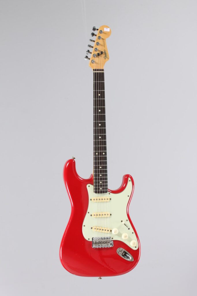 N° 114 - Guitare électrique solidbody FENDER, modèle Stratocaster, faite vers 1988, made in Japan, finition Coral Red. Collection Francis Kuntz. Instrument mis en vente par Vichy Enchères le 7 novembre 2026. © Vichy Enchères / Photo C. Darbelet