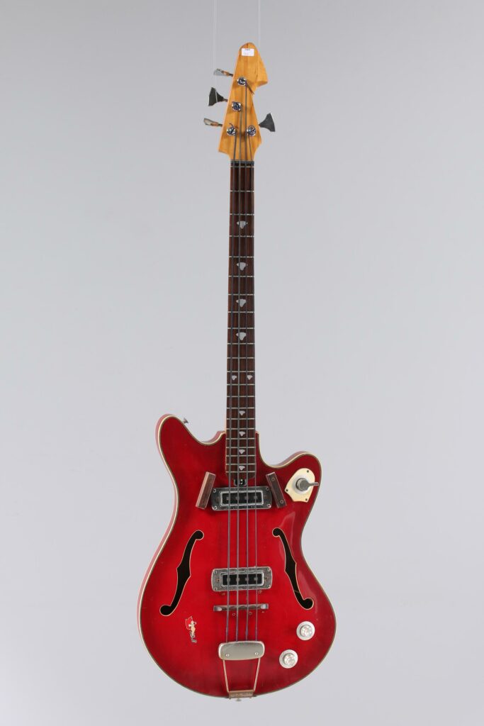 N° 124 - Guitare basse électrique hollowbody TEISCO, modèle n°EP-200B, faite vers 1960, made in Japan, finition Red. Collection Francis Kuntz. Instrument mis en vente par Vichy Enchères le 7 novembre 2026. © Vichy Enchères / Photo C. Darbelet