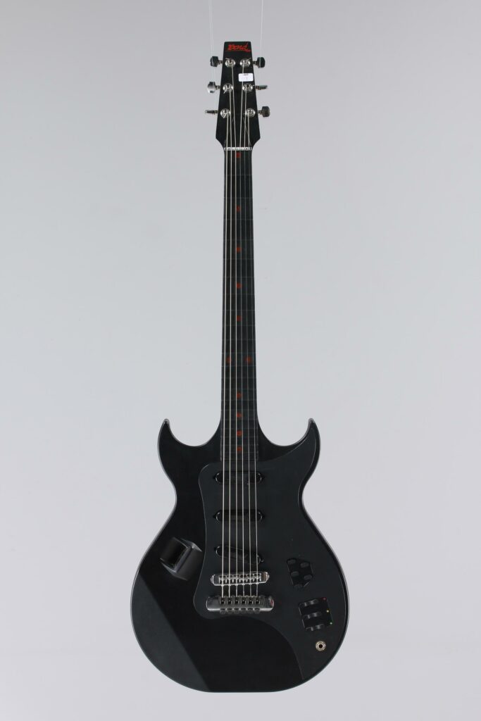 N° 127 - Guitare électrique solidbody BOND, modèle Electraglide faite en 1985, made in UK, finition Black Mat. Collection Francis Kuntz. Instrument mis en vente par Vichy Enchères le 7 novembre 2026. © Vichy Enchères / Photo C. Darbelet