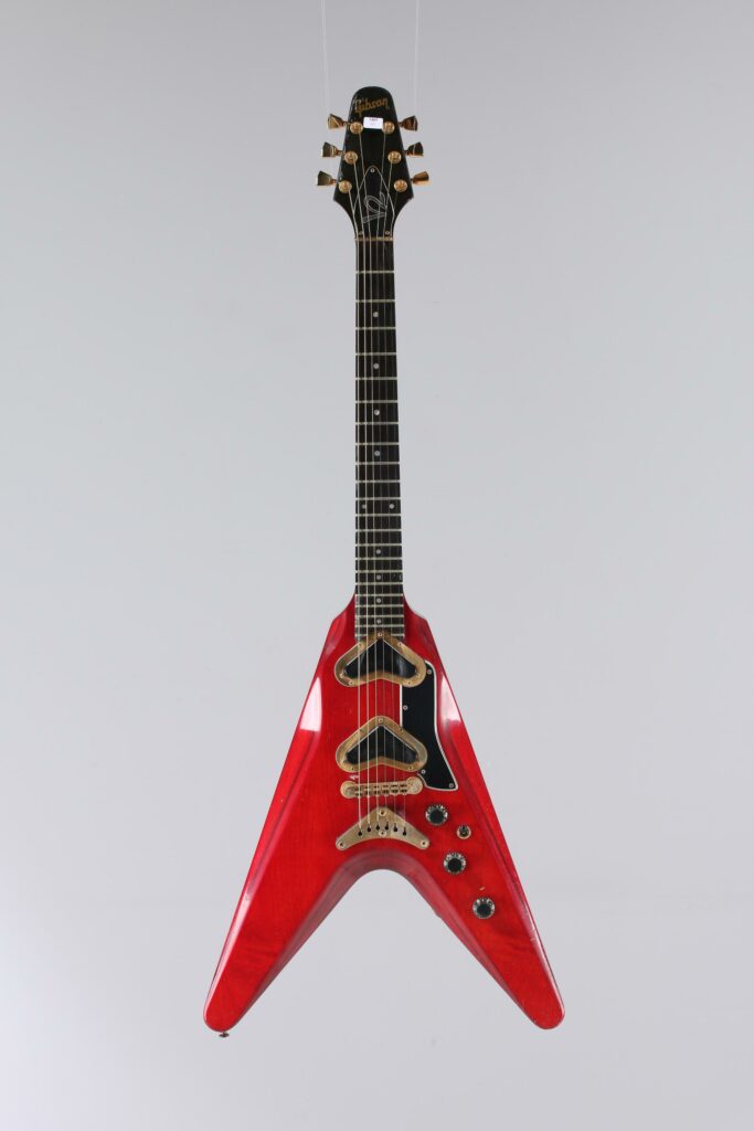 N° 136 - Guitare électrique solidbody GIBSON, modèle Flying V 2, faite en 1980, made in USA, finition Cherry. Collection Francis Kuntz. Instrument mis en vente par Vichy Enchères le 7 novembre 2026. © Vichy Enchères / Photo C. Darbelet