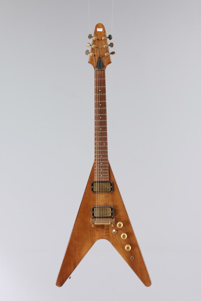 N° 137 - Guitare électrique solidbody flying V O'HAGAN, product of Gemma Corp, faite vers 1982, made in USA, finition Natural. Collection Francis Kuntz. Instrument mis en vente par Vichy Enchères le 7 novembre 2026. © Vichy Enchères / Photo C. Darbelet